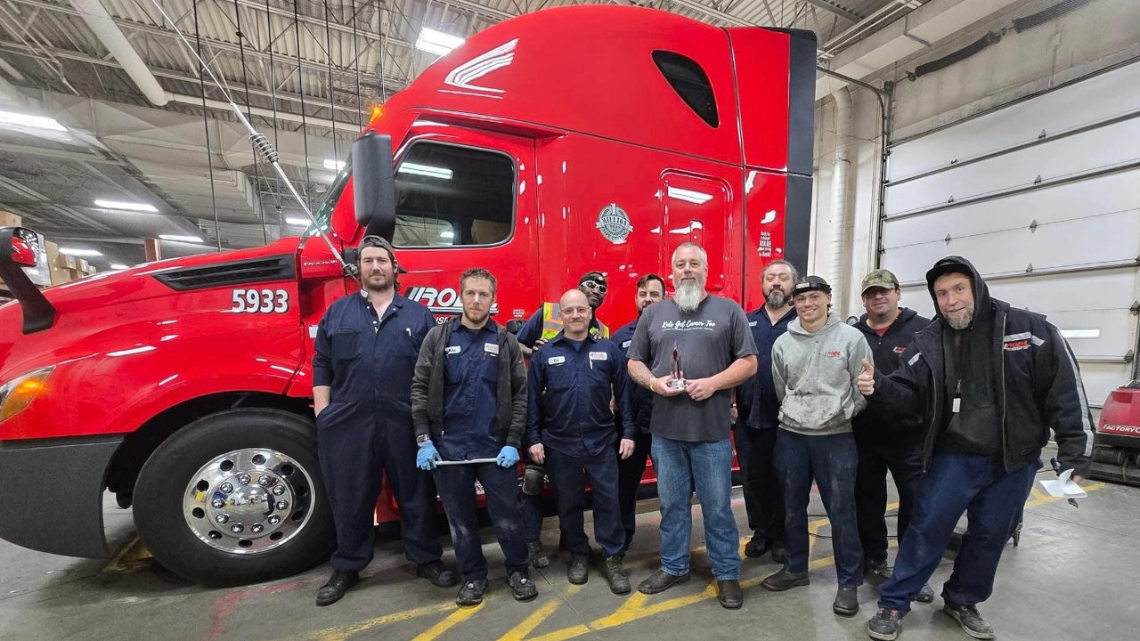 Tom Miller holding his 1 Million Mile Safe Driver Award surrounded by teammates