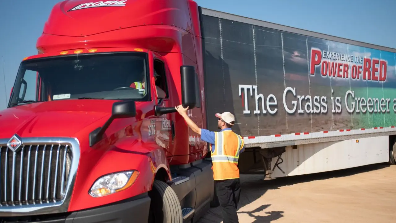 Instructor helping truck driving school student in truck