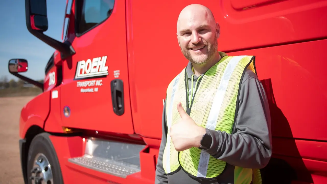 Smiling person next to a Roehl Transport truck